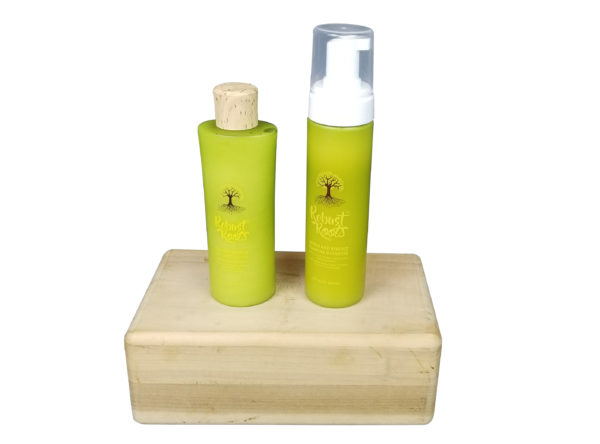 Two bottles of reroot roots hair care products on a wooden block.